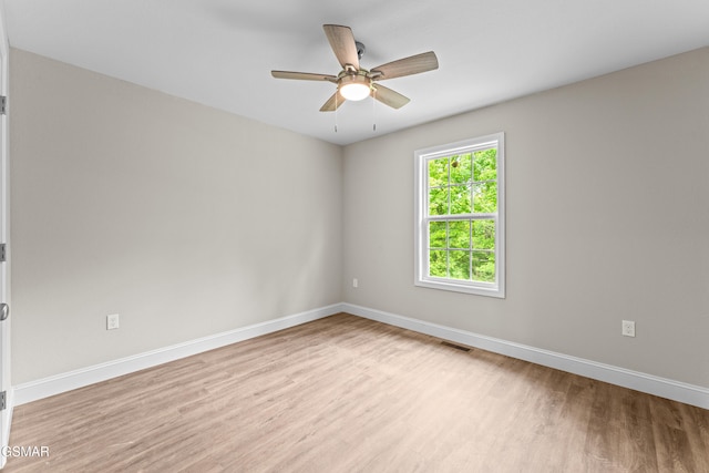 spare room featuring wood finished floors, baseboards, and a ceiling fan