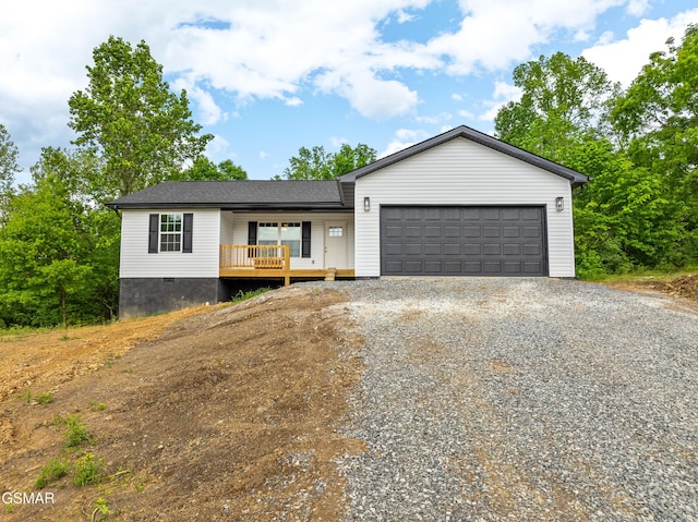 view of front of house featuring gravel driveway, an attached garage, crawl space, and a porch