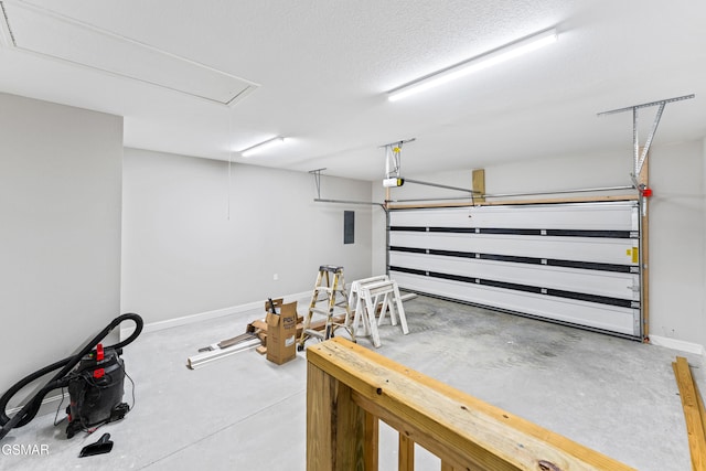 garage featuring baseboards, a garage door opener, and electric panel