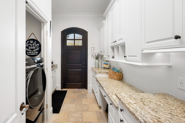 laundry area featuring cabinets, washer / dryer, and crown molding