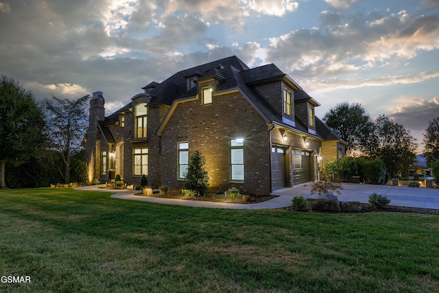 property exterior at dusk with a lawn and a garage