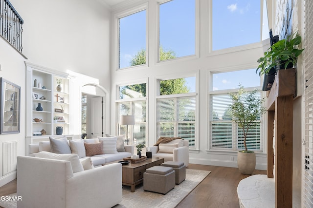 living room featuring wood-type flooring and a towering ceiling