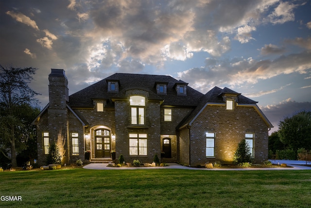 french country home featuring a yard and french doors