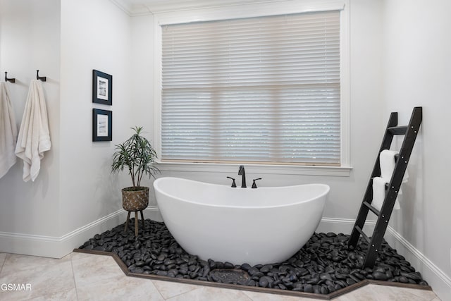 bathroom with crown molding, a bathtub, and tile patterned flooring