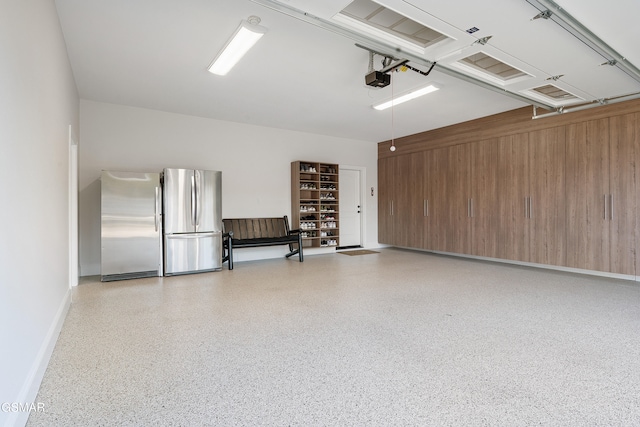 garage featuring wood walls, stainless steel fridge, and a garage door opener