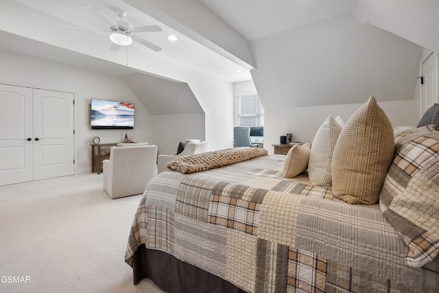 bedroom featuring ceiling fan, a closet, light carpet, and lofted ceiling