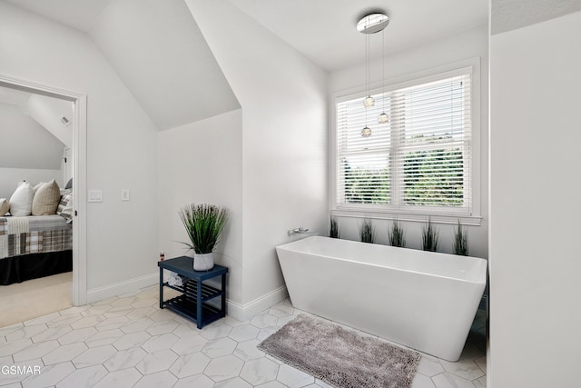 bathroom featuring a healthy amount of sunlight, a bath, and vaulted ceiling