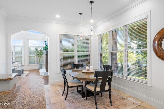 dining area with ornamental molding, light tile patterned floors, and a healthy amount of sunlight