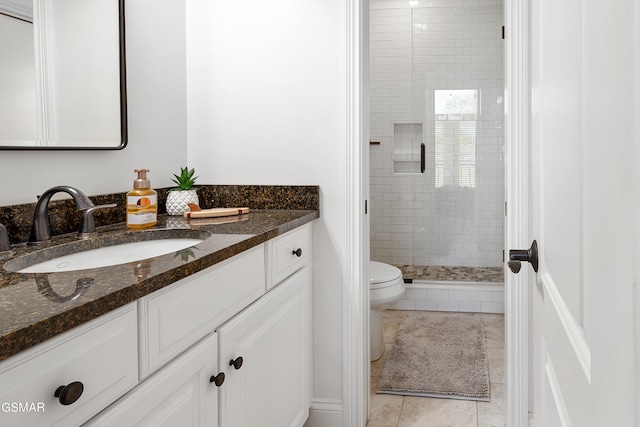 bathroom with tile patterned flooring, vanity, toilet, and a shower with door