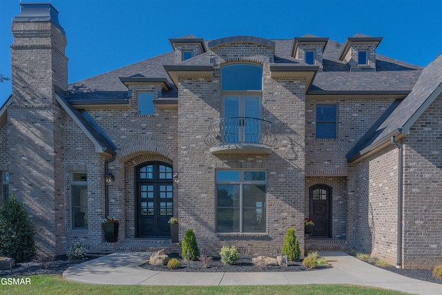 french country home with french doors and a balcony