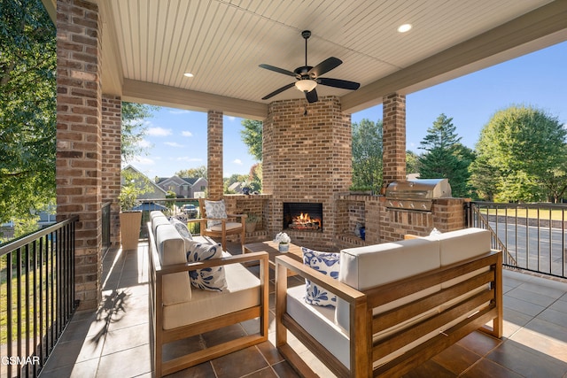 view of patio with an outdoor living space with a fireplace, ceiling fan, area for grilling, and exterior kitchen