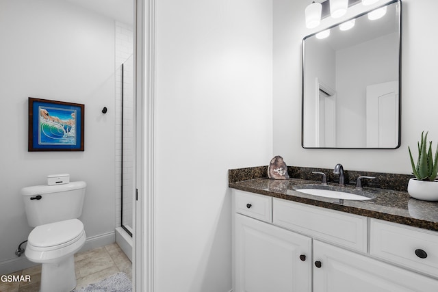 bathroom with tile patterned floors, vanity, a shower with shower door, and toilet