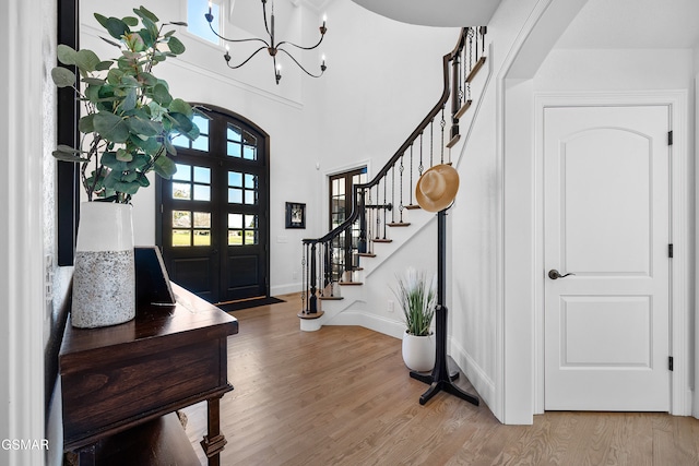 entryway with french doors, a notable chandelier, and hardwood / wood-style flooring