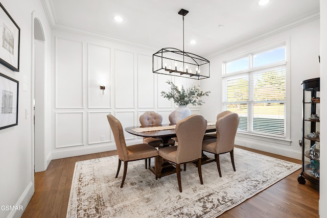 dining area featuring hardwood / wood-style floors, a notable chandelier, and ornamental molding