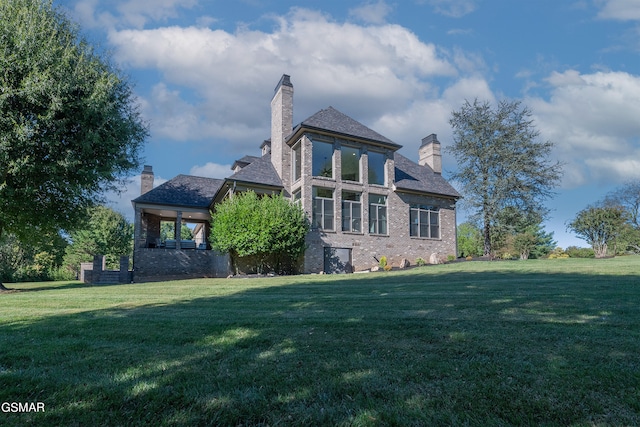 rear view of property featuring a lawn