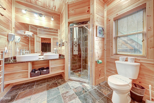 bathroom with walk in shower, vanity, wood walls, and toilet