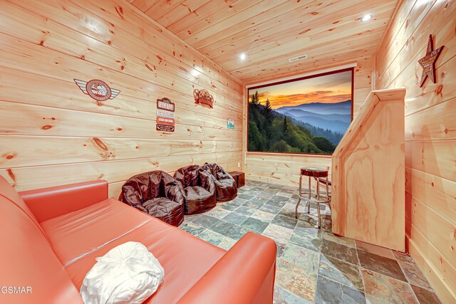 home theater room featuring wood ceiling and wood walls