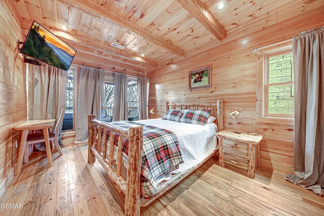 bedroom with wood ceiling, hardwood / wood-style flooring, beamed ceiling, and wooden walls