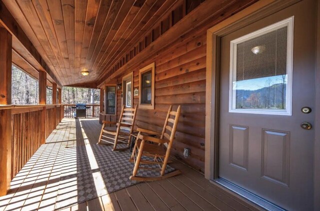 wooden terrace with a porch and grilling area