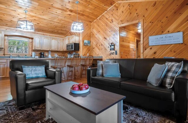 living room with wood ceiling, wooden walls, and vaulted ceiling