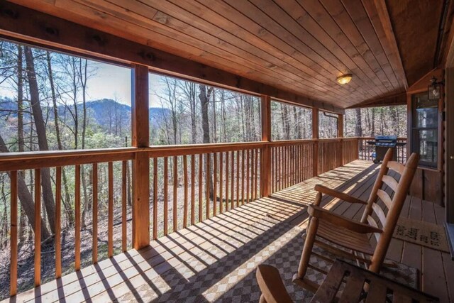 wooden deck with a grill and a mountain view