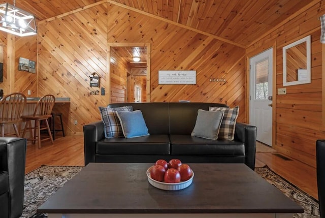 living room featuring vaulted ceiling, wood walls, and wood ceiling