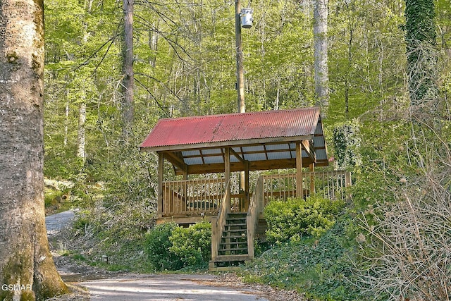 view of property's community with a wooded view, stairs, and a deck