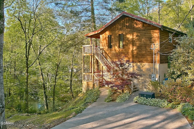 exterior space featuring stairway and a view of trees