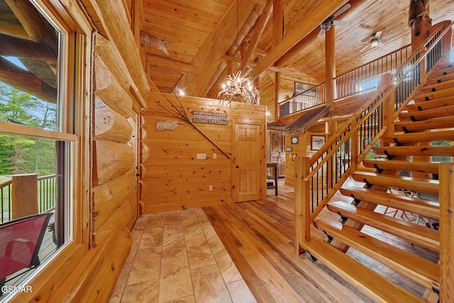 stairs with vaulted ceiling with beams, hardwood / wood-style flooring, wooden walls, and wood ceiling