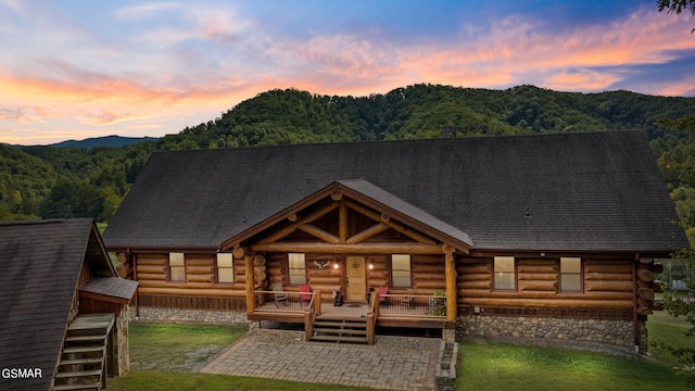 back house at dusk with a lawn