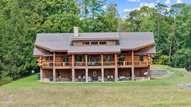 rear view of property with a deck and a yard