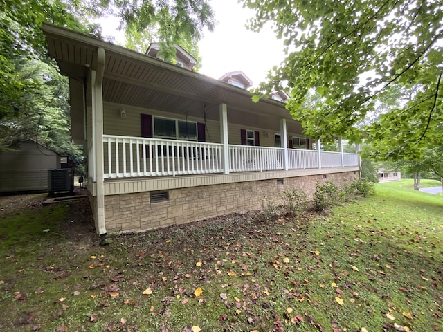 rear view of house featuring cooling unit and a yard