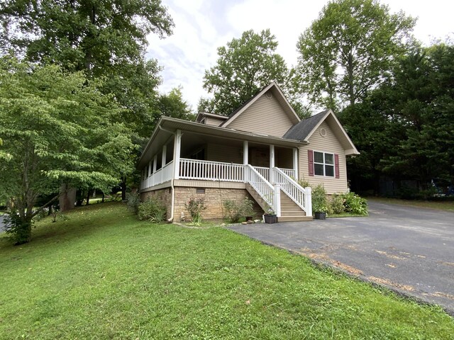 view of front of house with covered porch and a front lawn