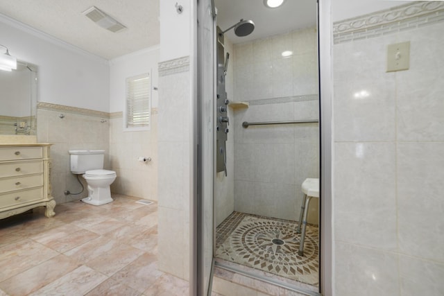 bathroom with crown molding, a textured ceiling, tiled shower, vanity, and tile walls