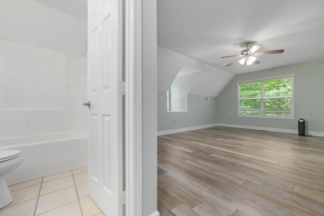 additional living space with ceiling fan, light tile patterned floors, and vaulted ceiling