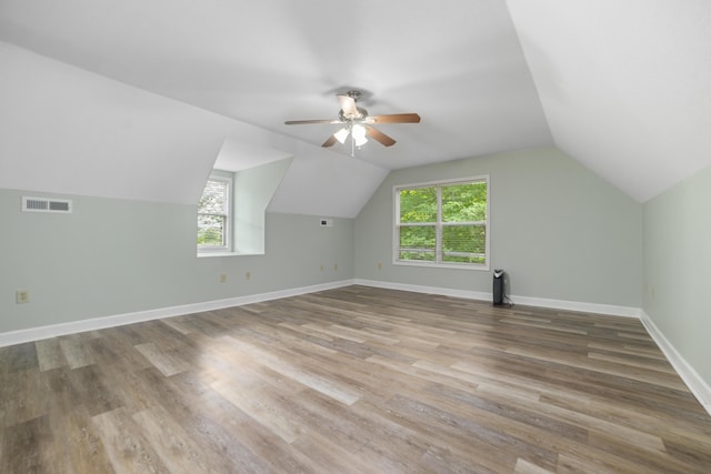 additional living space with hardwood / wood-style floors, vaulted ceiling, and ceiling fan