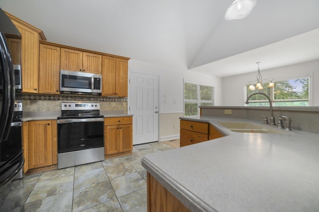 kitchen featuring sink, pendant lighting, a chandelier, decorative backsplash, and appliances with stainless steel finishes