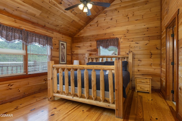 bedroom featuring wood walls, vaulted ceiling, ceiling fan, wood-type flooring, and wood ceiling