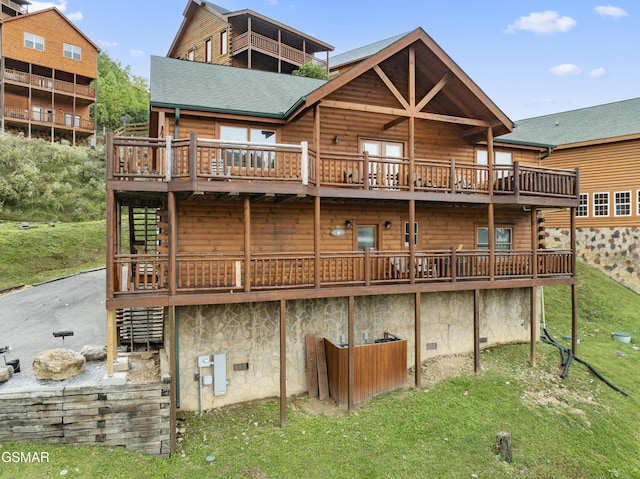 back of house featuring a lawn and a wooden deck