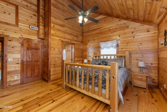 bedroom with vaulted ceiling, ceiling fan, wooden walls, light hardwood / wood-style flooring, and wooden ceiling