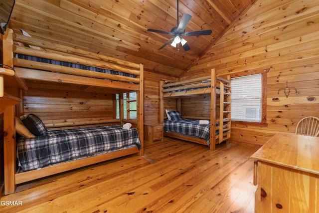 bedroom with wood walls, lofted ceiling, ceiling fan, light hardwood / wood-style floors, and wood ceiling