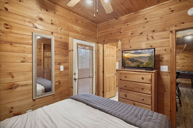 bedroom with ceiling fan, wood walls, and wood ceiling