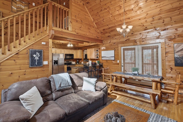 living room featuring wood walls, wooden ceiling, high vaulted ceiling, hardwood / wood-style flooring, and a notable chandelier