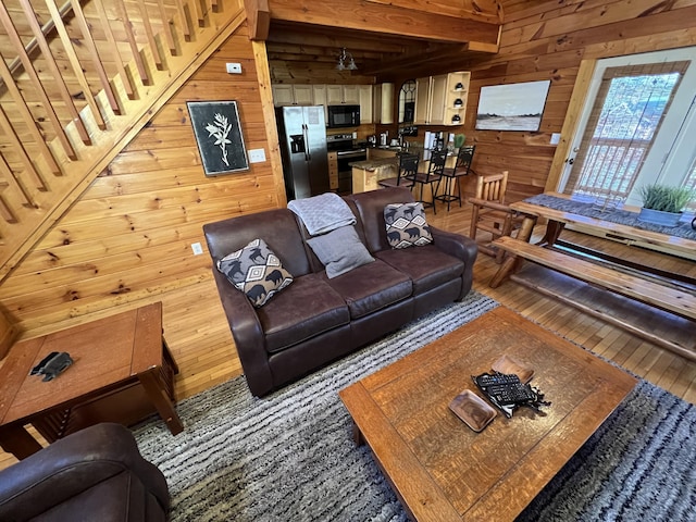 living room with hardwood / wood-style floors and wooden walls