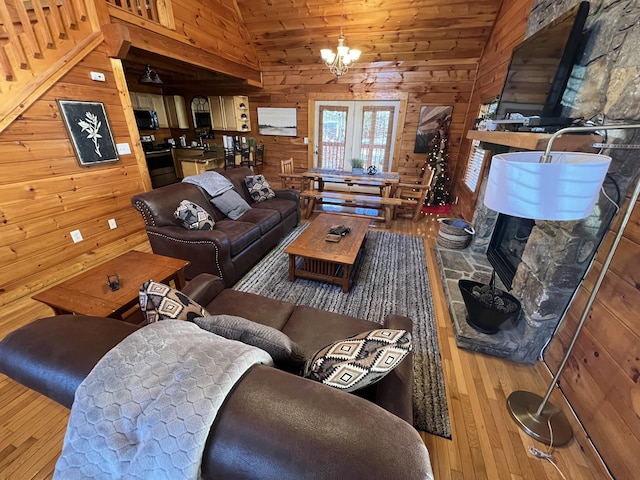 living room with a fireplace, hardwood / wood-style floors, lofted ceiling, and a notable chandelier