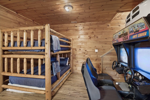 bedroom featuring hardwood / wood-style floors, wooden walls, lofted ceiling, and wooden ceiling