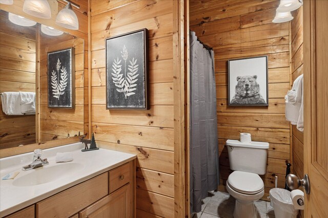 bathroom with vanity, toilet, and wood walls