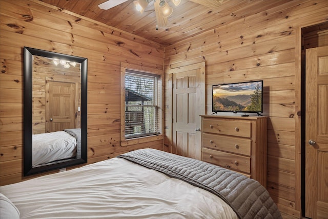 bedroom with ceiling fan, wood walls, and wooden ceiling