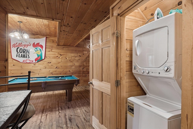 rec room with wood ceiling, wooden walls, hardwood / wood-style floors, stacked washer and dryer, and pool table