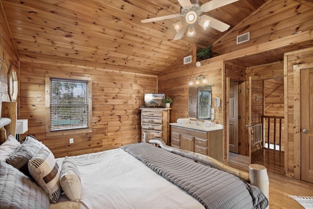 bedroom featuring wooden walls, vaulted ceiling, ceiling fan, light wood-type flooring, and wood ceiling